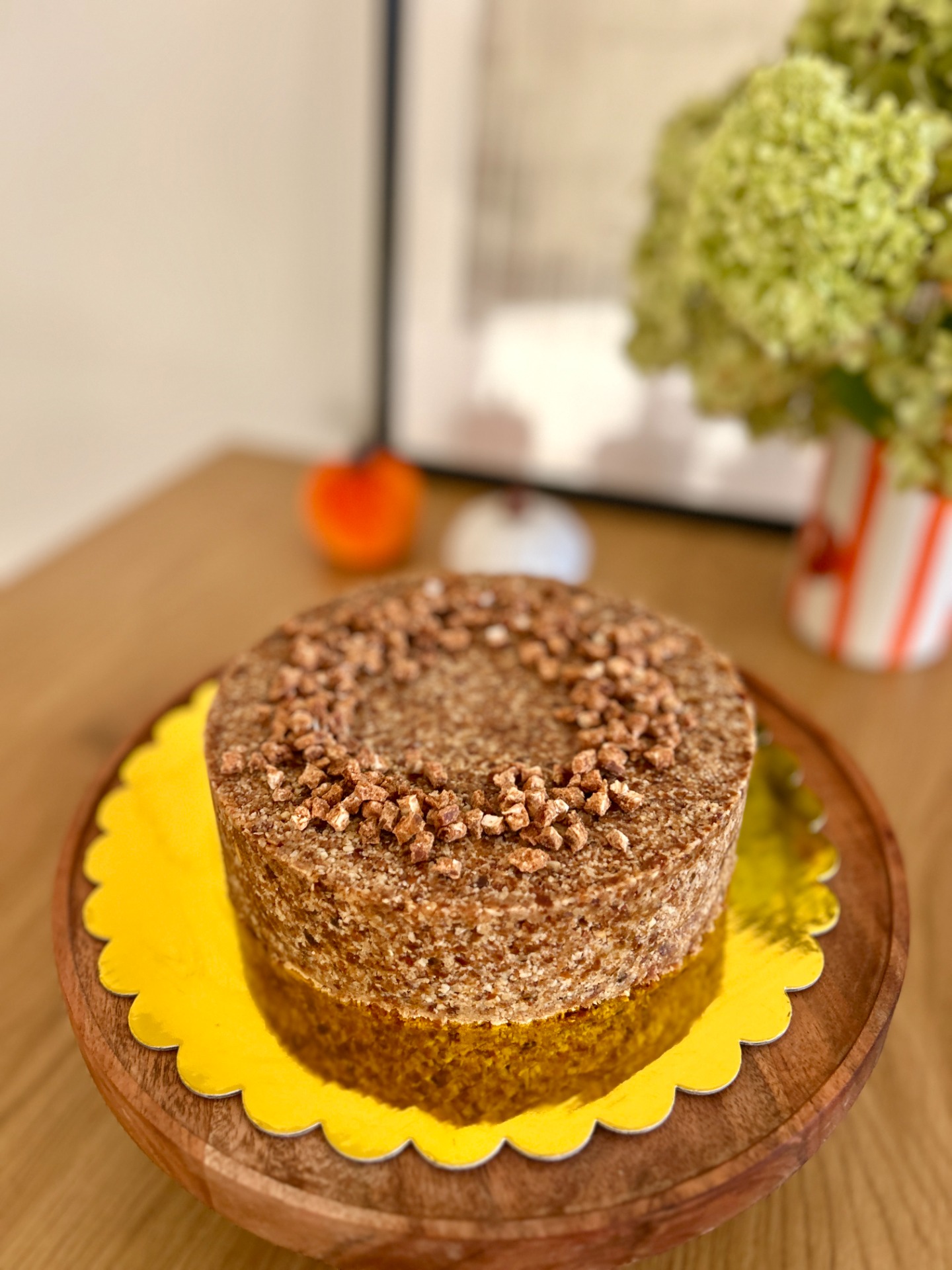 Fordított sütőtökös sajttorta közeli képe, fahéjas, gyömbéres növényi krémmel és természetesen édes, ropogós mandulás-zabos réteggel.
